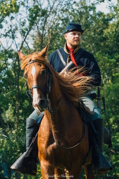A cavalry soldier on horseback, dressed in a classic military uniform, exuding a sense of readiness and valor. The soldier sits tall in the saddle, with a confident expression, showcasing the pride and tradition of cavalry units as they prepare for action on the battlefield.
